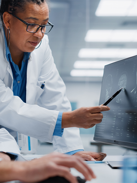 Medavis Portrait 2  woman in lab coat pointing at scan