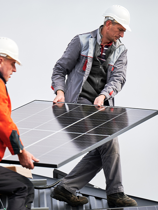 Solo Portrait 3 men lifting solar panel