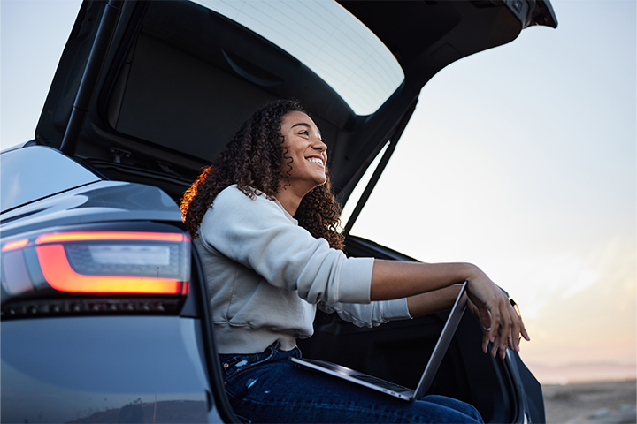 Enprecis Landscape 1 woman with laptop in trunk of car